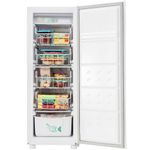 Freezer vertical posicionado de frente com a porta aberta abastecido de alimentos congelados