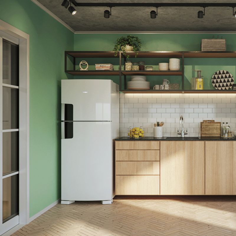 Geladeira branca duplex com puxador preto nas duas portas, posicionada em um armário de parede em uma cozinha com paredes verdes.