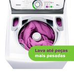 Vista superior da máquina de lavar roupas com a tampa aberta e com um edredom roxo em seu interior